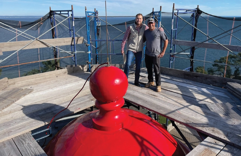 two men getting a picture taken from the top of the light house