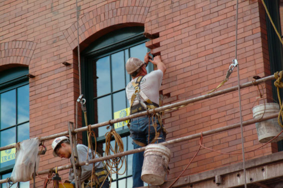 Worker restores brick building